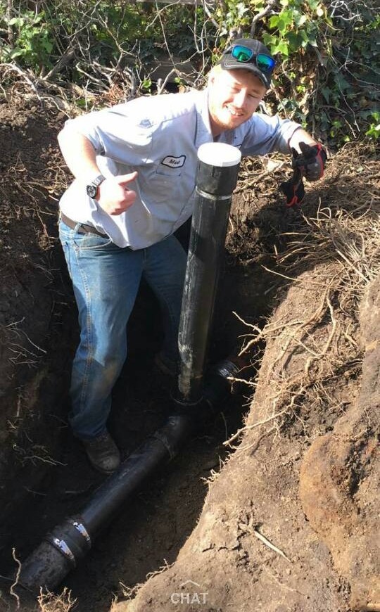 Mark's Sewer & Drain crew member replacing a sewer line and cleanout in an excavated trench